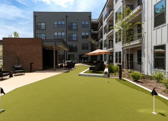 a courtyard with synthetic grass and umbrellas at Abberly Riverwalk Apartment Homes, Tennessee