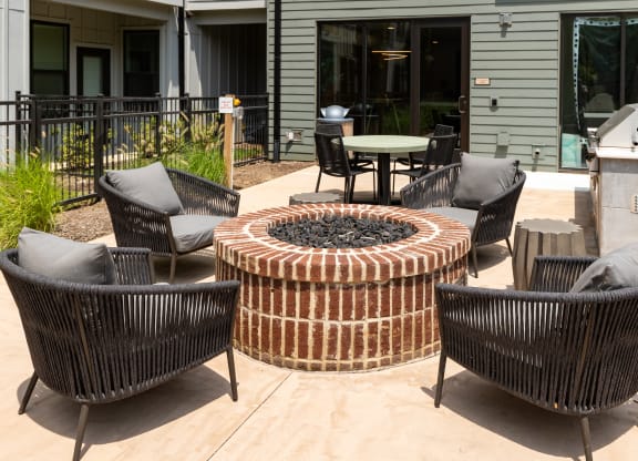 an outdoor patio with a firepit and wicker chairs at Abberly Riverwalk Apartment Homes, Nashville, TN, 37228