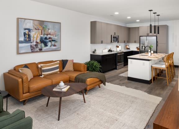 a living room with a couch coffee table and a kitchen in the background  at Abberly Riverwalk Apartment Homes, Nashville, 37228