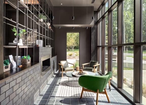 a living room with a fireplace and large windows at Abberly Riverwalk Apartment Homes, Tennessee
