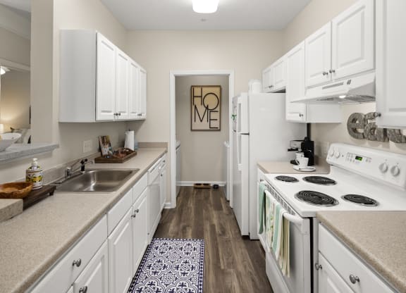 a kitchen with white cabinets and a white stove top oven  at Abberly Grove Apartment Homes, Raleigh, NC