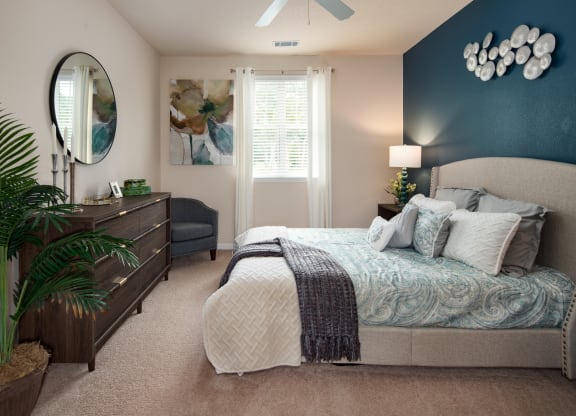 a bedroom with a large bed and a blue accent wall