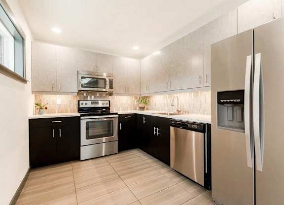 A modern kitchen with stainless steel appliances and wooden cabinets at Altitude Apartment , Tacoma, WA