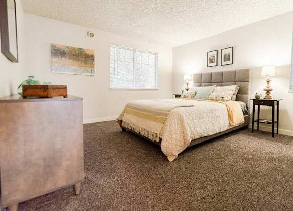 A bedroom with a bed, nightstand, and a painting on the wall at Altitude Apartment , Washington