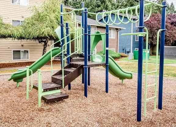 A playground with a green slide and a wooden platform at Altitude Apartment , Washington, 98444