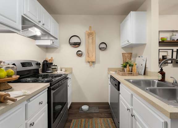 A kitchen with white cabinets and a black stove top.