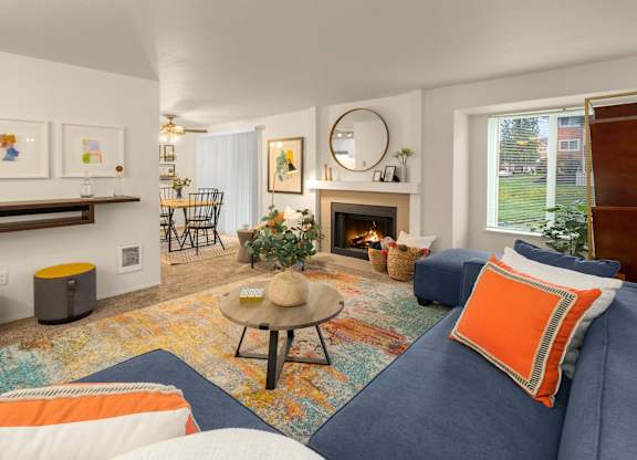 A living room with a fireplace and a blue couch.