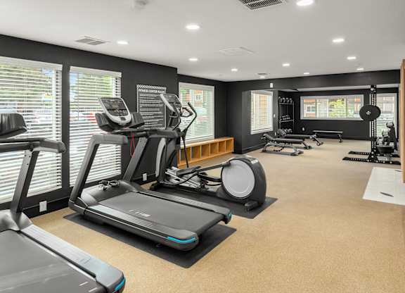 A spacious gym with treadmills, elliptical machines, and other exercise equipment.