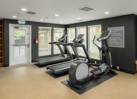 A gym with treadmills and a sign that says