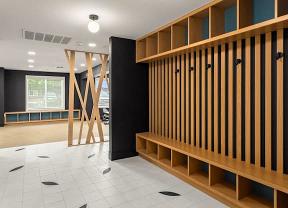 A room with a black wall and a wooden shelf.