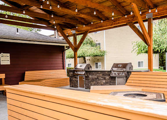 A wooden picnic table under a wooden pergola.