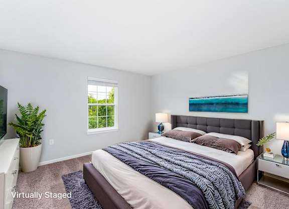 A bedroom with a large bed and a window.