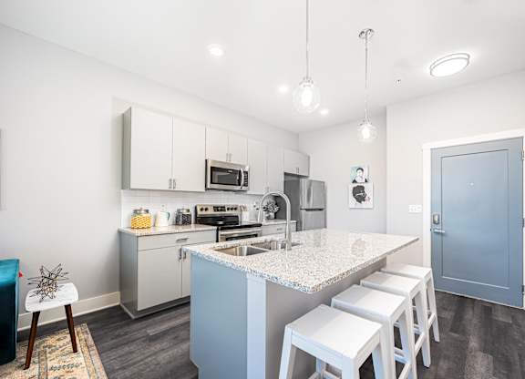 a kitchen with a marble counter top and white cabinets