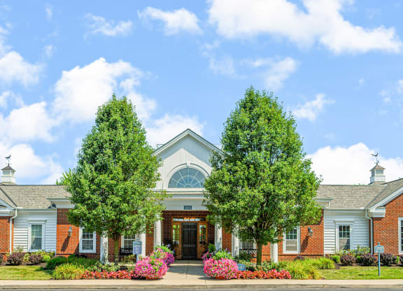the front of a building with two trees in front of it