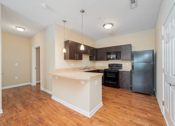 a kitchen with a large island and a black refrigerator