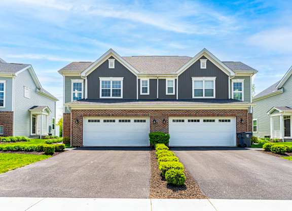 A two-car garage is in front of a house.