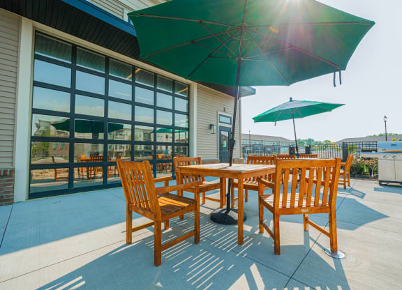 a patio with tables and umbrellas outside of a building