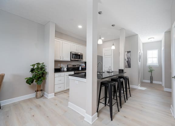 an open kitchen and dining room with bar stools