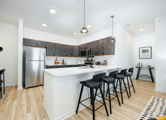 a kitchen with a large island with bar stools