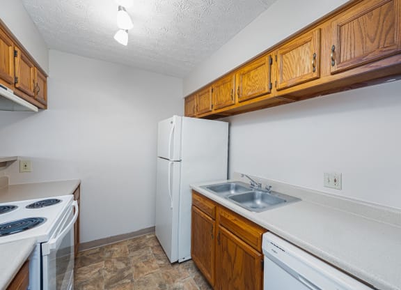 a kitchen with white appliances and wooden cabinets and a white refrigerator