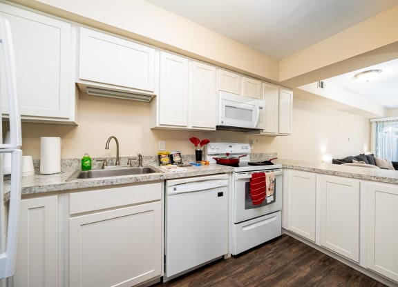 a kitchen with white cabinets and appliances and a sink