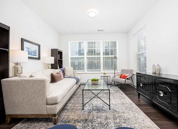 A living room with a couch, a chair, a coffee table, and a fireplace.