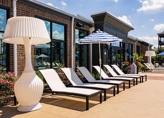 A row of sun loungers are arranged in front of a building.