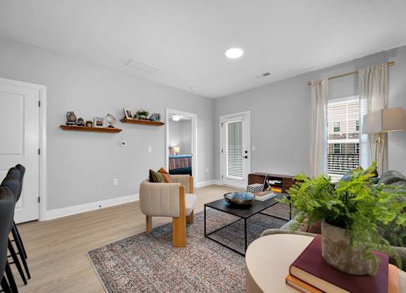 A living room with a couch, chair, and potted plant.