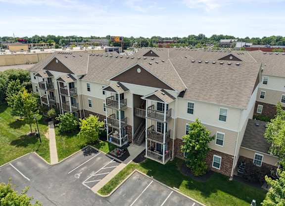 Apartment complex with a parking lot in front.