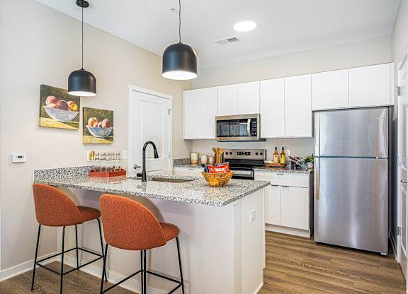 A kitchen with a granite countertop and a refrigerator.