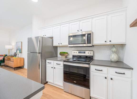 a kitchen with stainless steel appliances and white cabinets