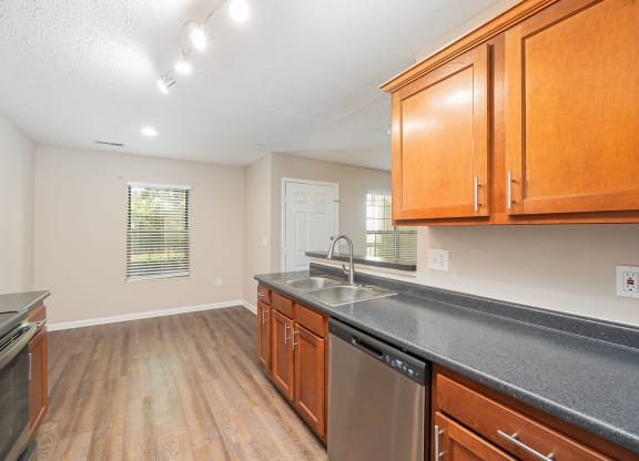 an empty kitchen with wood cabinets and a counter top and a sink