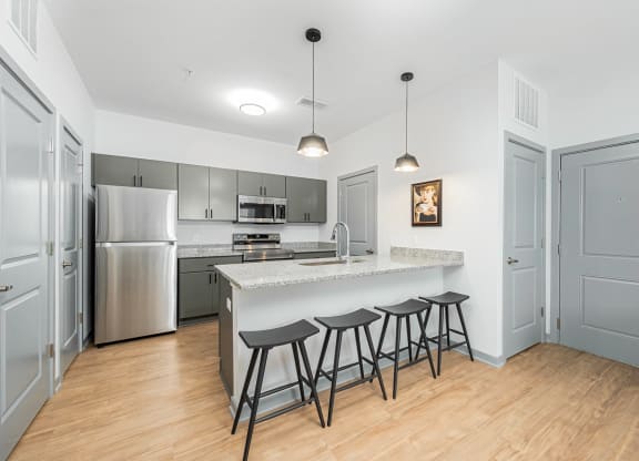 a kitchen with a large island with three bar stools