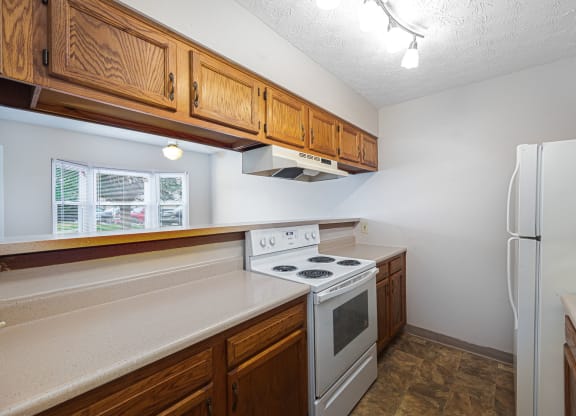 a kitchen with white appliances and wooden cabinets