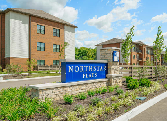 a sign flats in front of an apartment building
