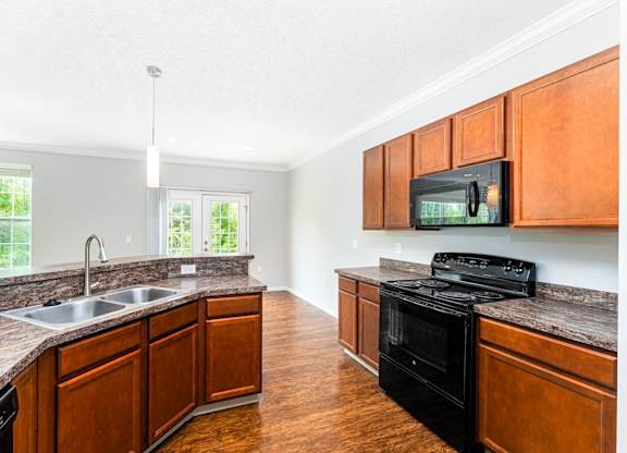 A kitchen with wooden cabinets and a black stove top oven.