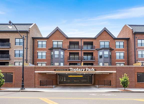 The image shows a multi-story building named Toplary Park with a parking lot in front.