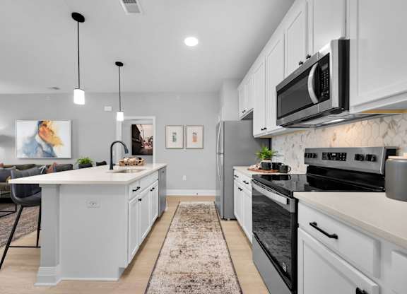 A modern kitchen with a large island and stainless steel appliances.