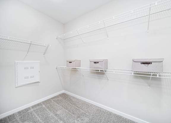 A white room with three shelves and a white wall.