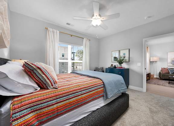 A bedroom with a bed, a dresser, and a mirror.