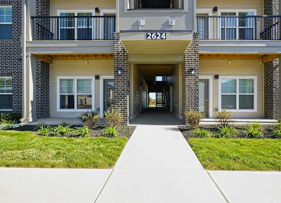 The image shows the front of apartment building number 2624 with a walkway leading to the entrance.