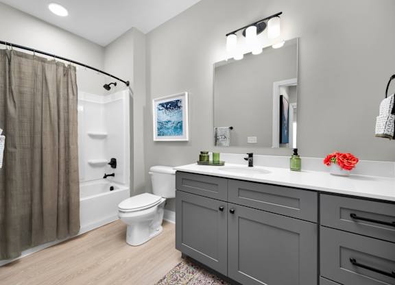 A bathroom with a toilet, sink, and shower.