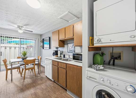 A small kitchen with a washing machine on top of the counter.