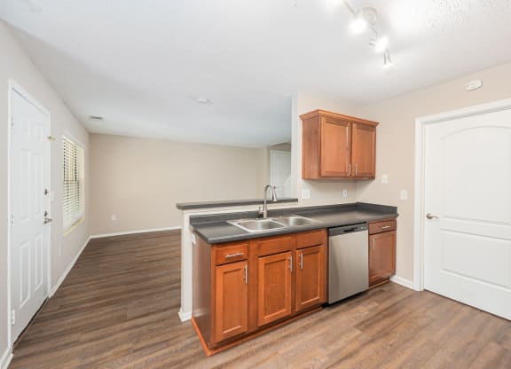 a kitchen with wooden cabinets and a stainless steel sink and a refrigerator