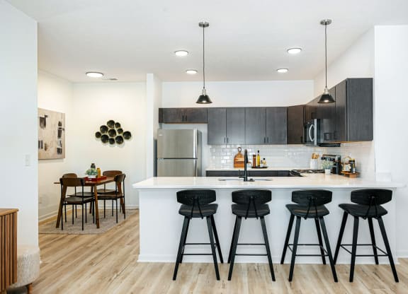 a kitchen with a large island with bar stools