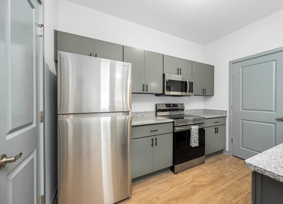 a kitchen with stainless steel appliances and gray cabinets