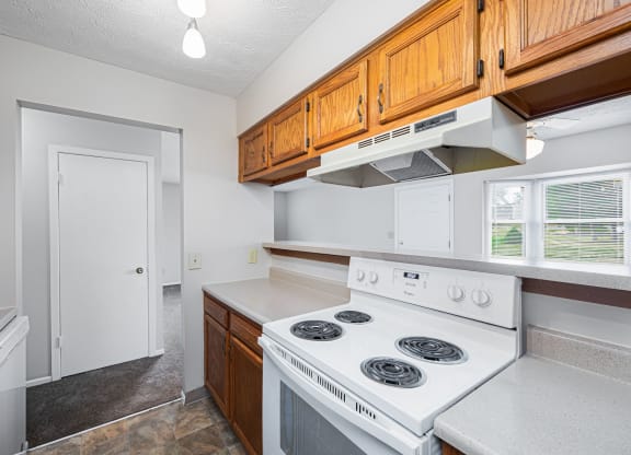 a kitchen with white appliances and wooden cabinets and a white stove