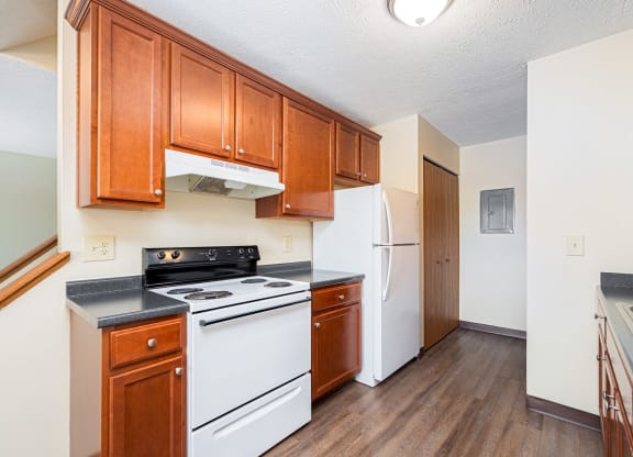 a kitchen with white appliances and wooden cabinets