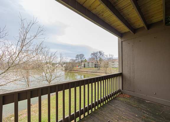A balcony with a view of a river and buildings.