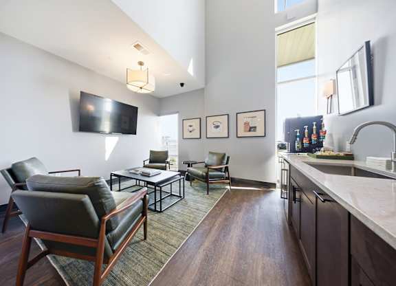A modern living room with a dark wood floor and furniture.